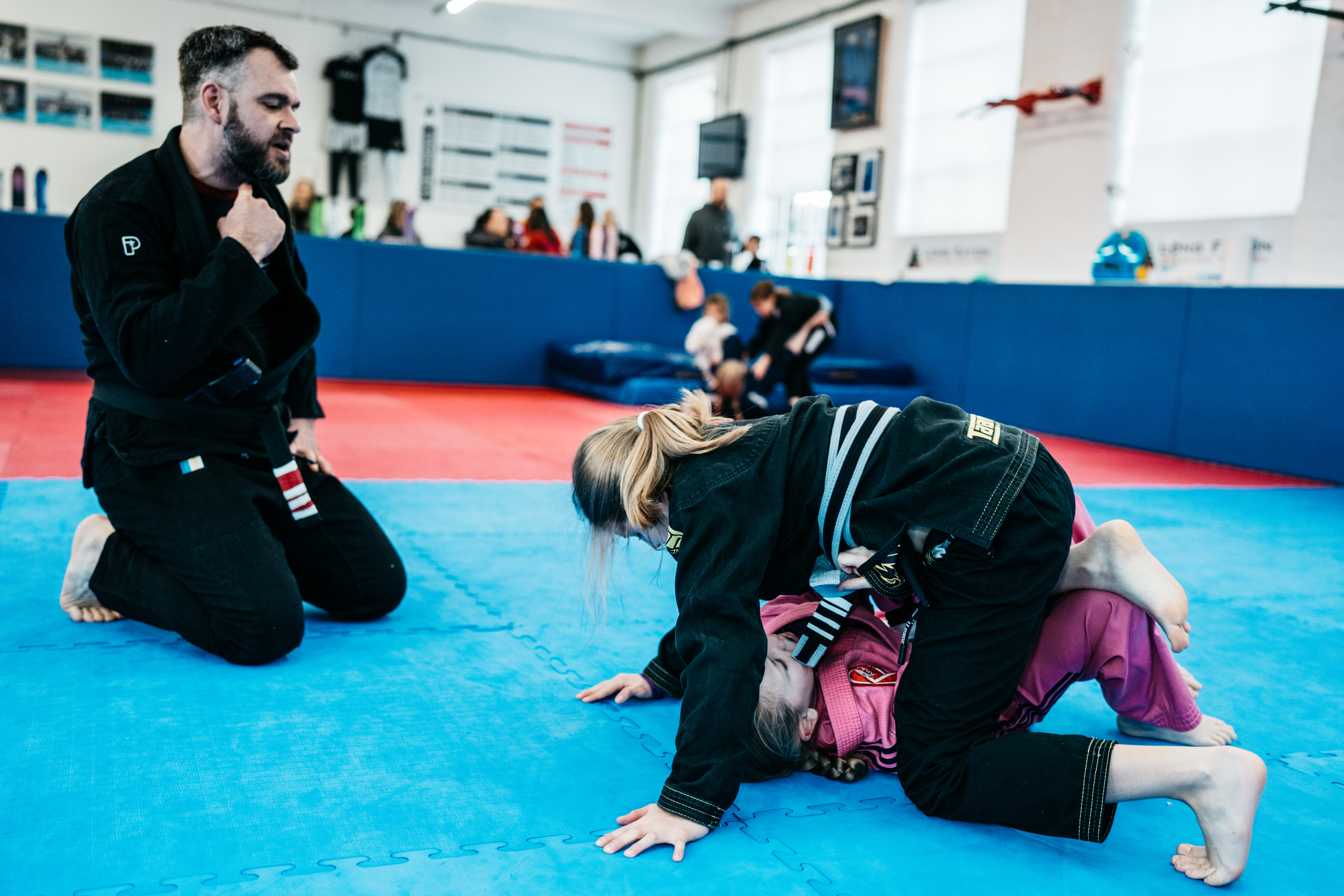 Instructor supervising two junior students during controlled sparring