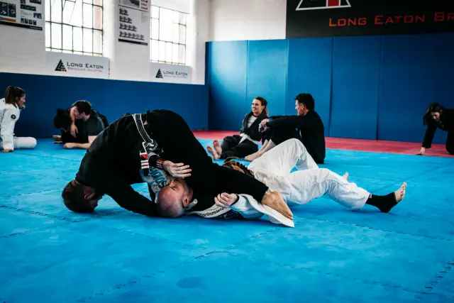 Two students engaged in a controlled sparring session during class at Long Eaton BJJ